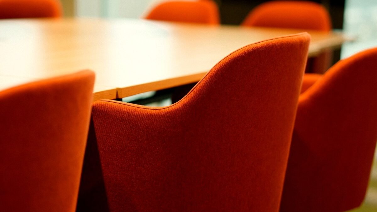 Close-up of orange chairs around a table in a modern meeting room