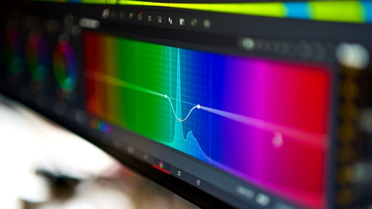 A close-up of a video editing timeline with colour grading panels on screen