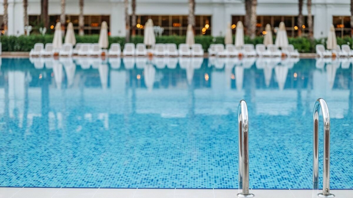 Empty swimming pool with a ladder at a bright hotel resort