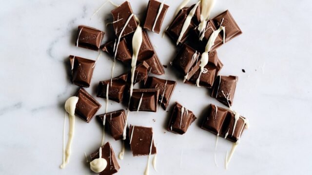 Squares of Cadbury milk chocolate arranged on a dark surface