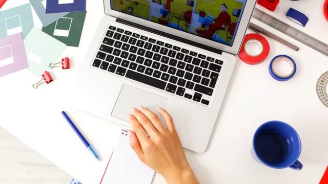 Laptop, notebook and design tools laid out on a bright desk