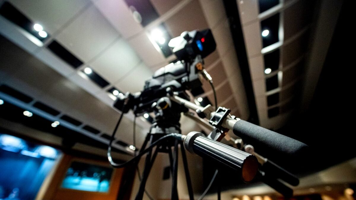 Video camera on a tripod under studio lights