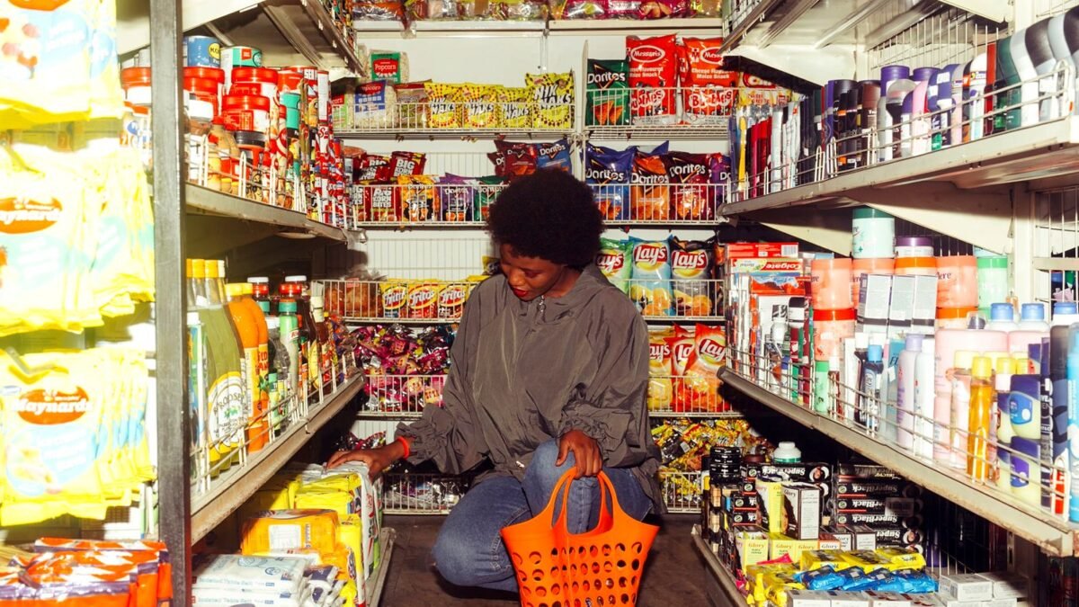 A shopper pays for a small basket of groceries at the till of a neighborhood convenience store.