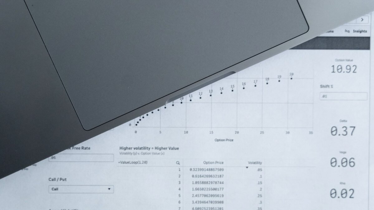 Printed data sheets with rows of figures spread across a desk