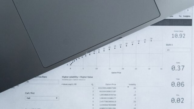 Printed data sheets with rows of figures spread across a desk
