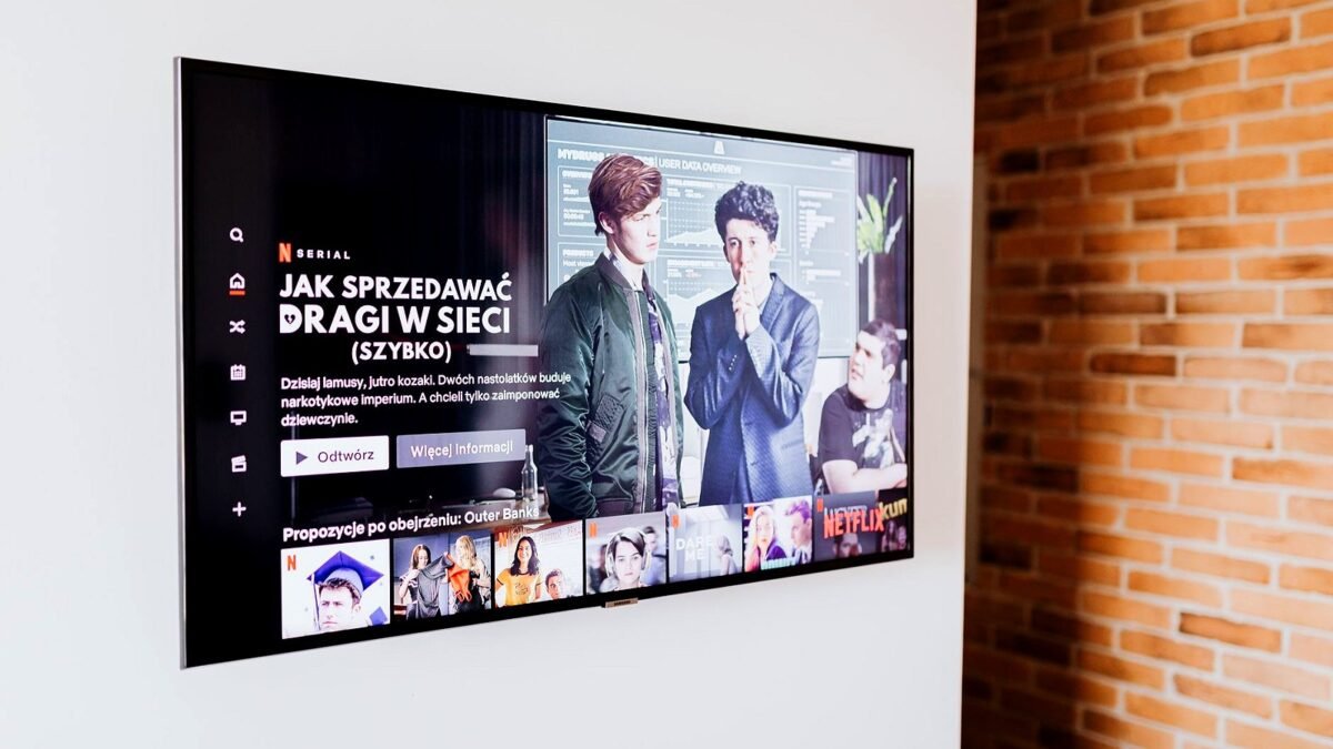Smart TV showing a streaming menu in a bright living room with a brick wall