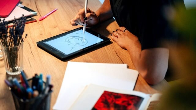 Designer drawing brand marks on a graphics tablet at a studio desk