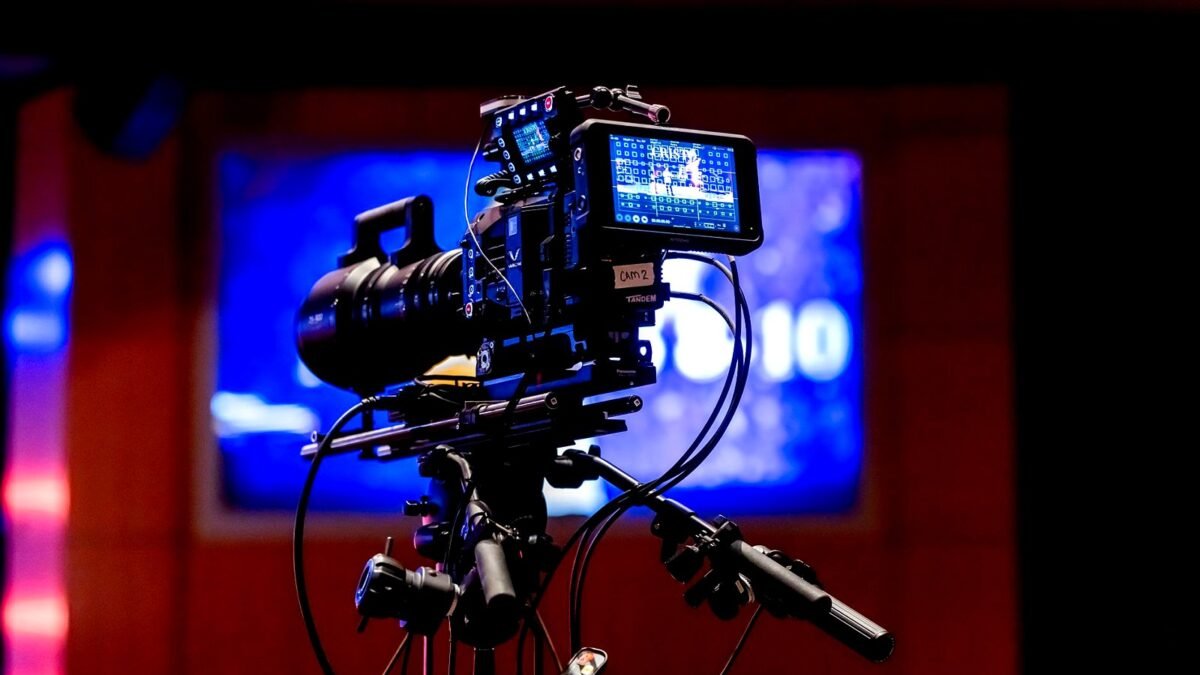 Studio camera pointed at a brightly lit television set during a recording