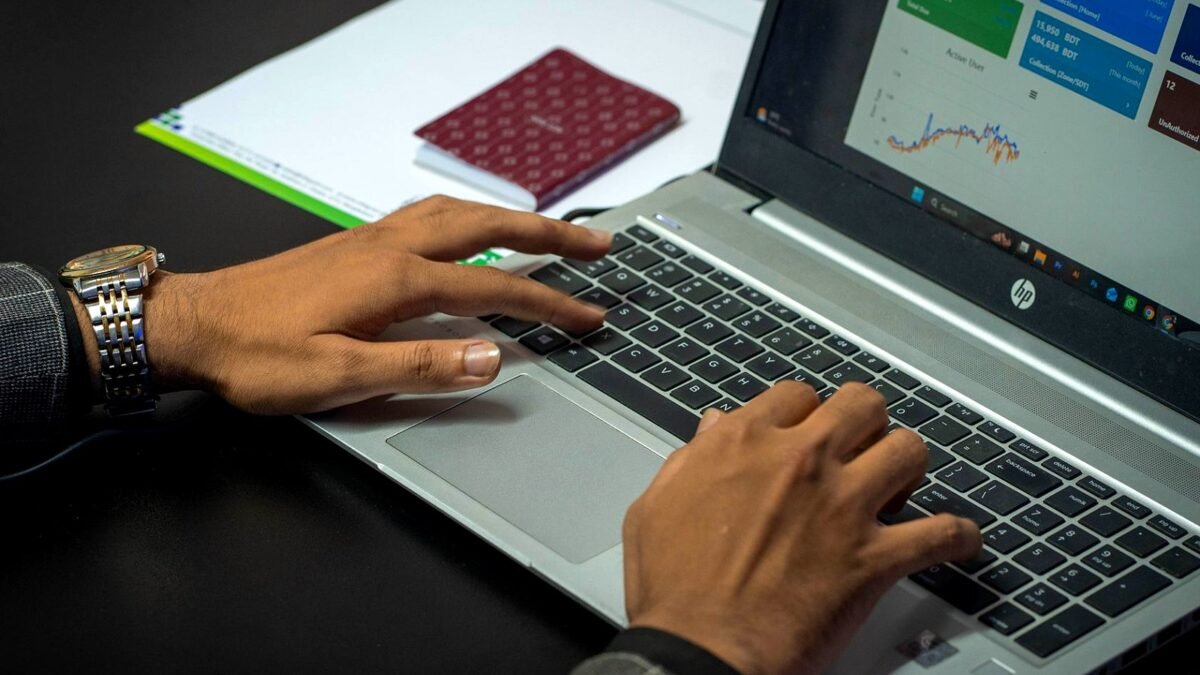 Hands on a laptop keyboard with an advertising results dashboard on the screen