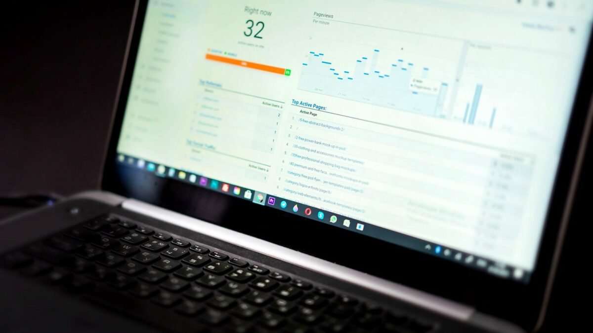 A laptop on a desk showing an analytics dashboard with charts and traffic figures