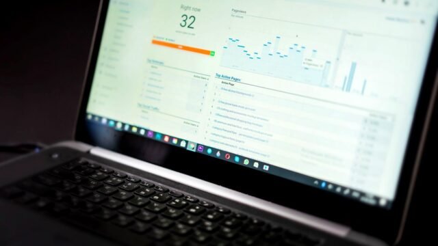 A laptop on a desk showing an analytics dashboard with charts and traffic figures