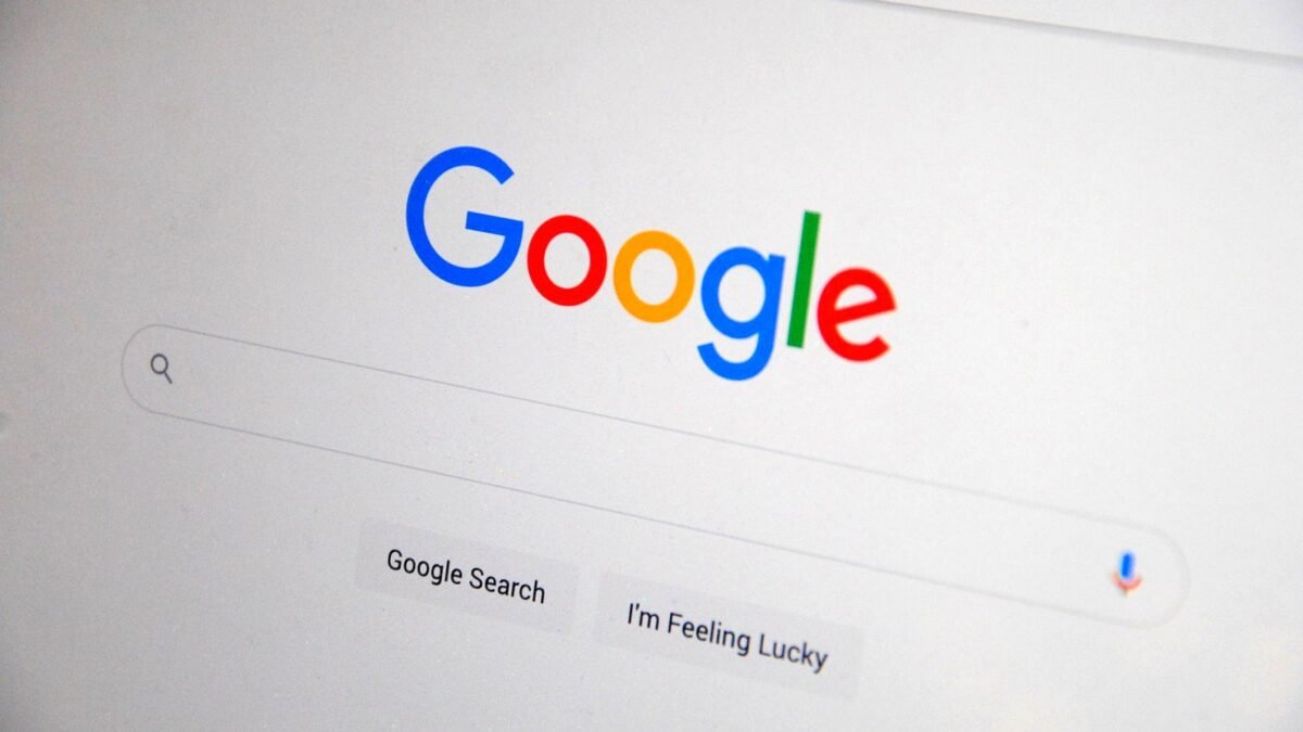 Close-up of a screen showing the Google search page on a bright desk.