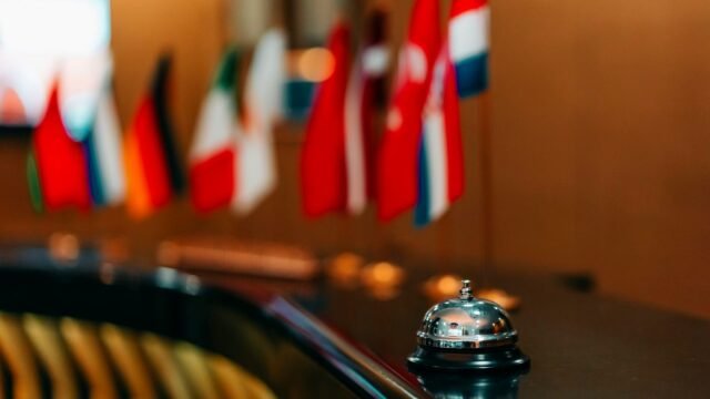 Hotel lobby reception desk with a service bell and a row of flags