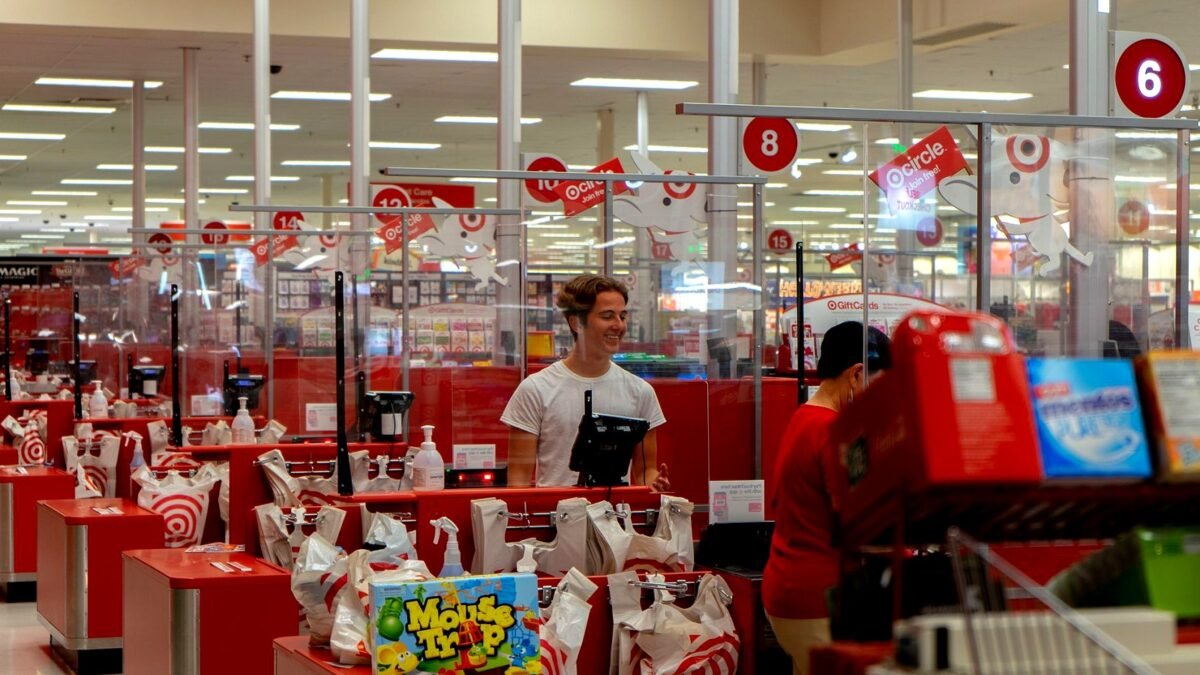 A busy checkout area in a large retail store with shoppers queuing
