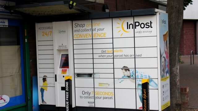 InPost parcel locker on a London street with a touch screen and yellow sun logo