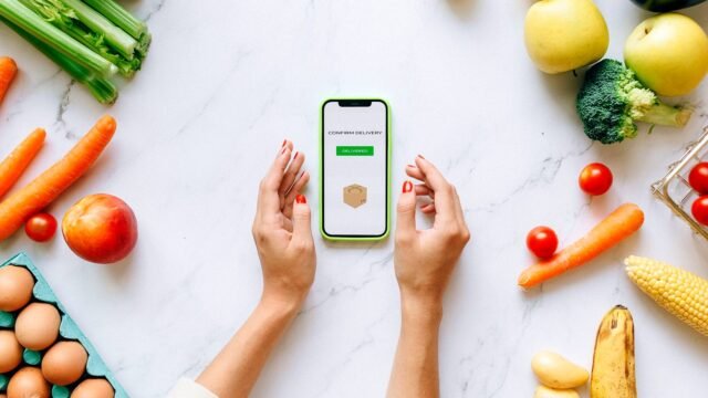 Hands holding a phone with an online grocery order on the screen