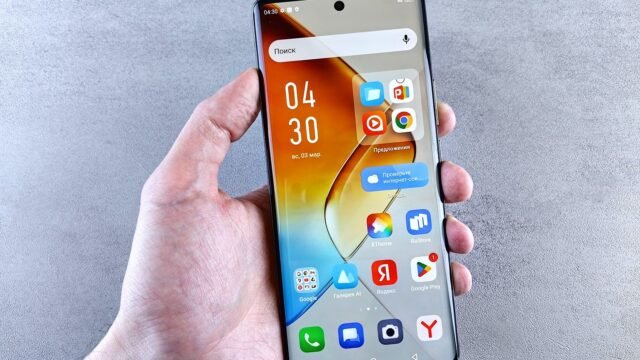 A hand holds a smartphone with the app screen lit up, seen close up against a textured background.