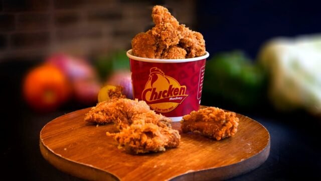 Bucket of fried chicken on a table in a restaurant, illustrating the KFC menu overhaul