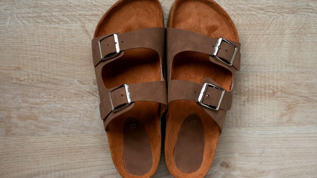 Brown leather sandals with buckled straps, photographed close up.