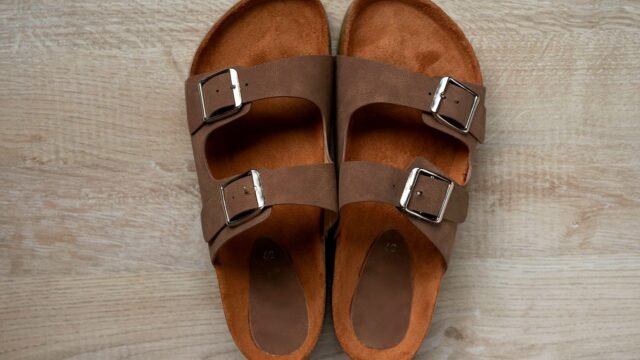 Brown leather sandals with buckled straps, photographed close up.