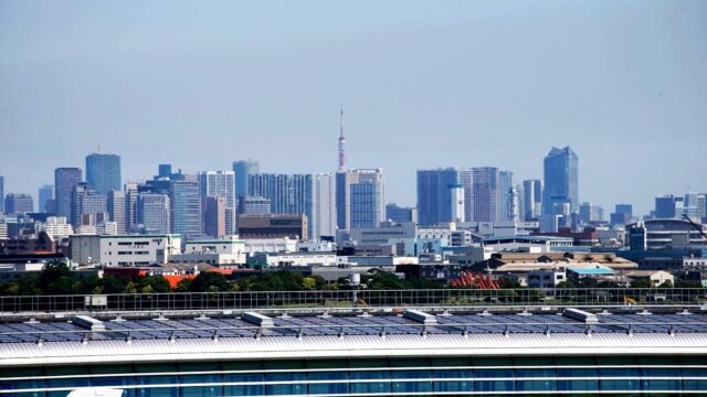 Aerial view of Tokyo skyscrapers with Tokyo Tower visible, showcasing urban architecture.