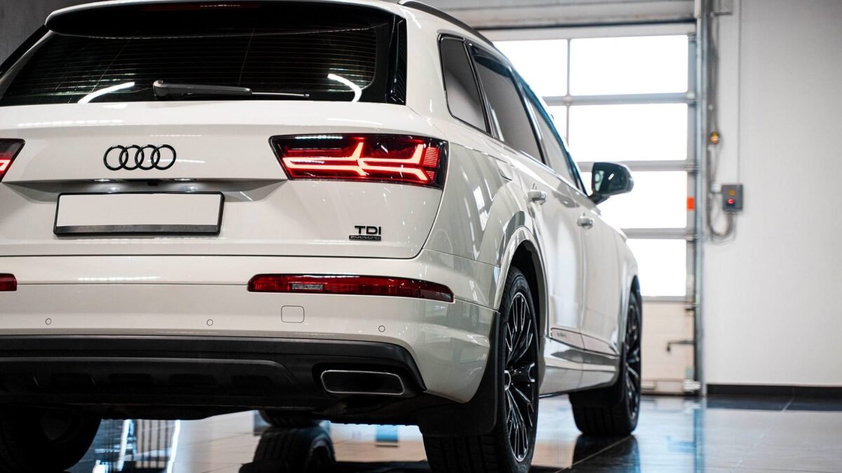 Close-up of the four-ring Audi emblem on the grille of a white SUV