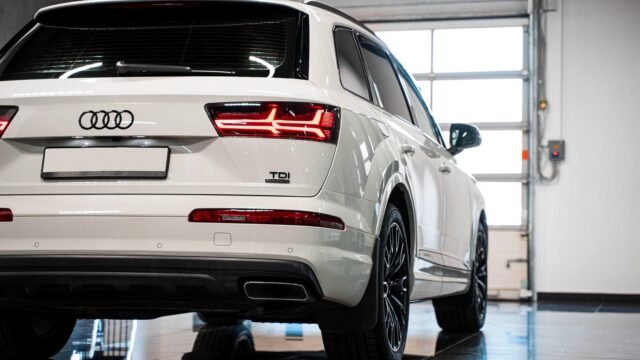 Close-up of the four-ring Audi emblem on the grille of a white SUV