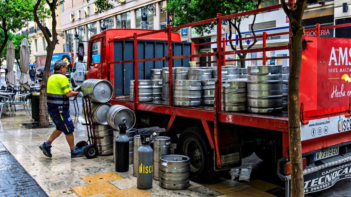 Man unloading beer kegs from a truck in Valencia, Spain.