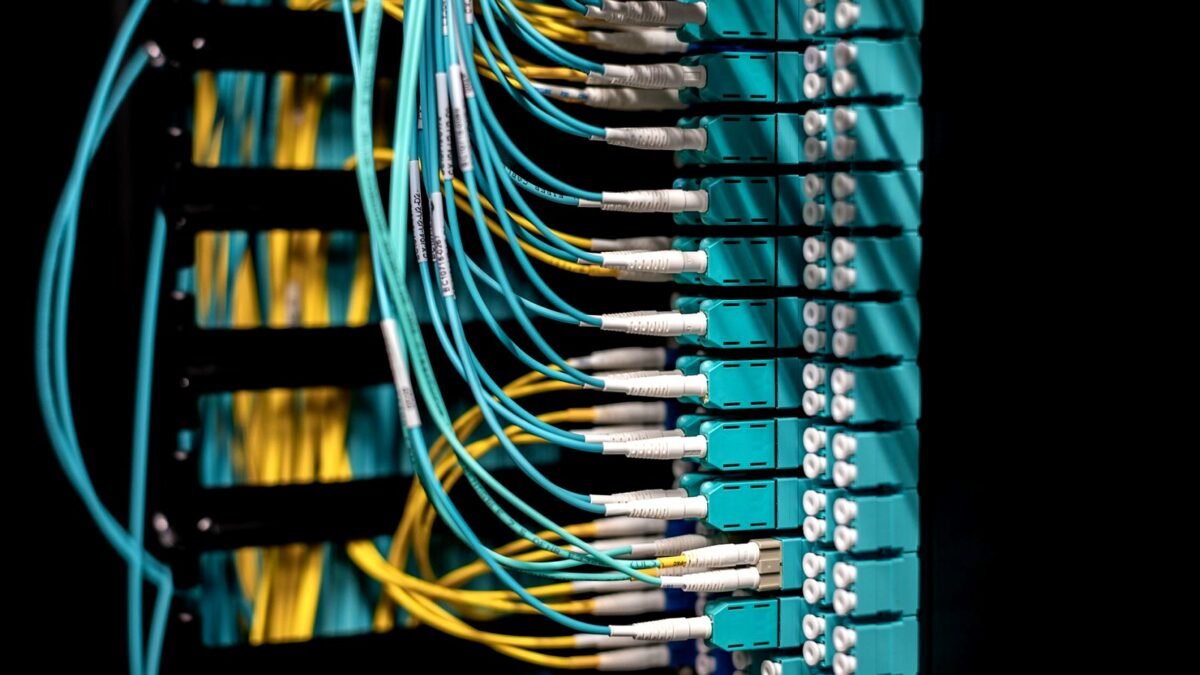 Close-up of network switch ports with fibre optic cables plugged in
