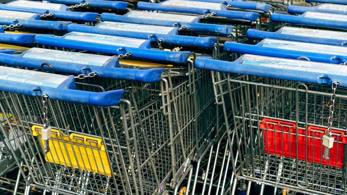 A row of nested shopping trolleys outside a supermarket.