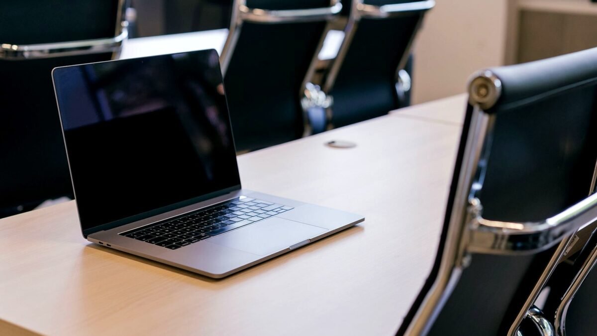Open laptop on a conference table in an empty meeting room