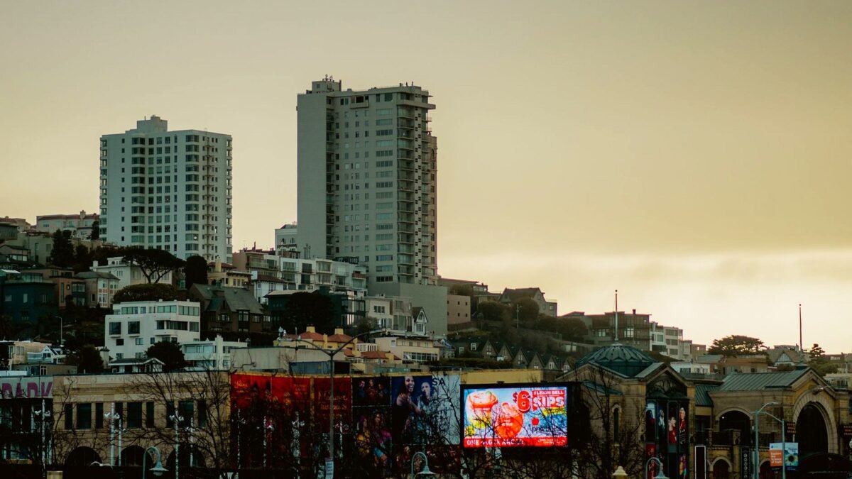 San Francisco skyline with prominent billboards during a calm dusk sky, showcasing urban architecture.