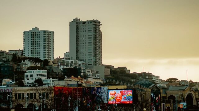 San Francisco skyline with prominent billboards during a calm dusk sky, showcasing urban architecture.