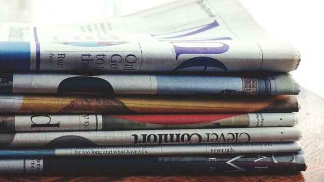 A stack of printed newspapers piled one on another