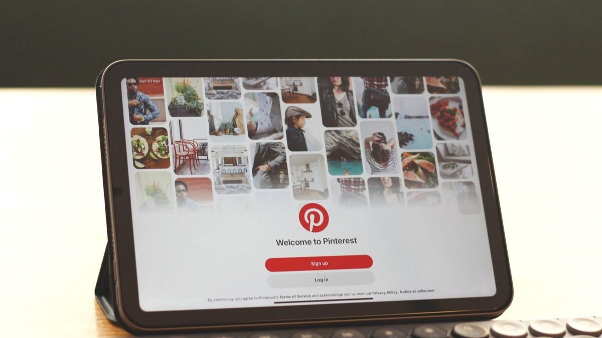 Tablet on a desk showing the Pinterest home feed next to a keyboard