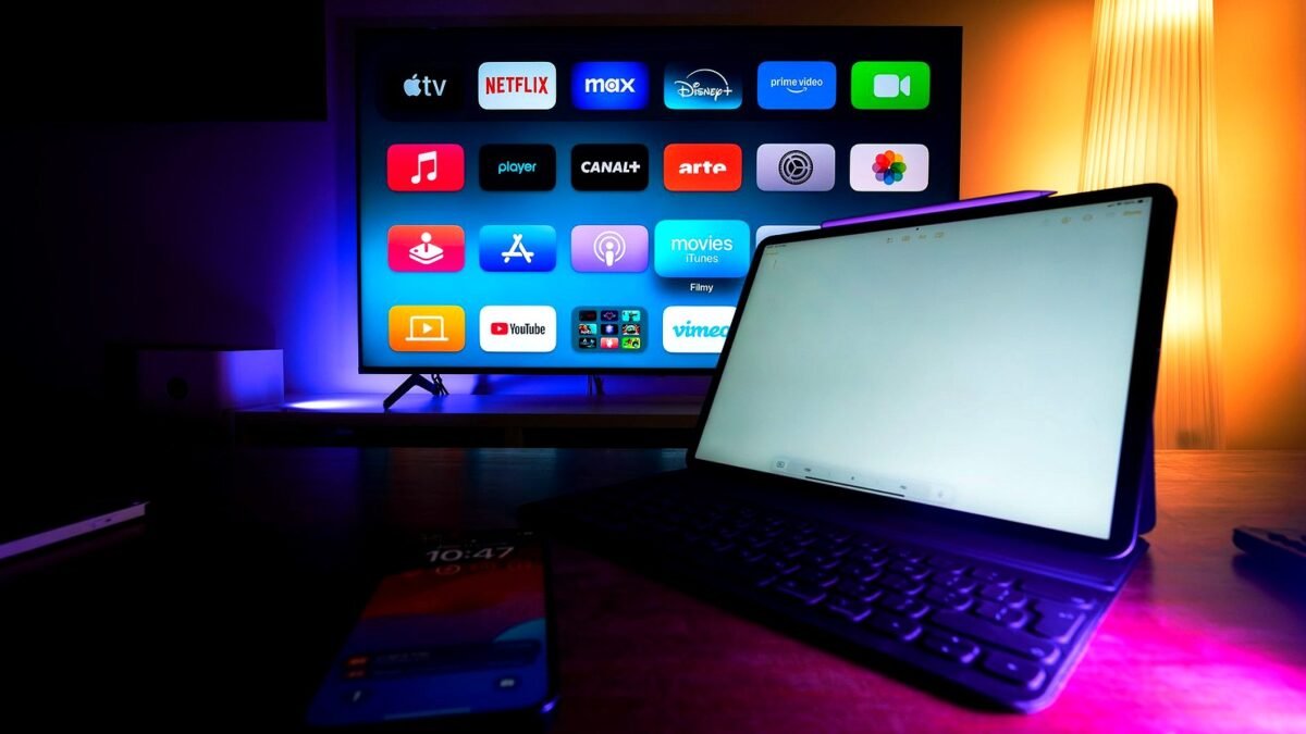 A smart TV and a tablet in a living room showing streaming app tiles