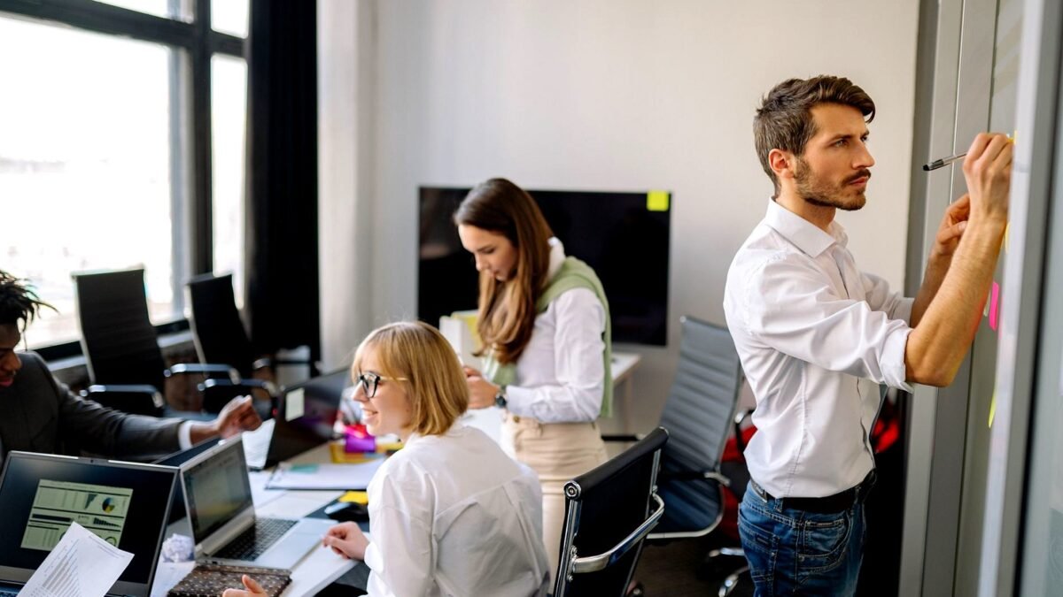 Colleagues going through notes together at a table during an office meeting