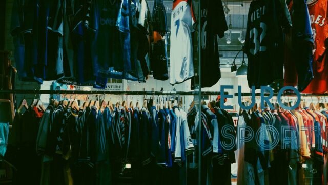 Rails of sportswear and trainers on display inside a clothing shop