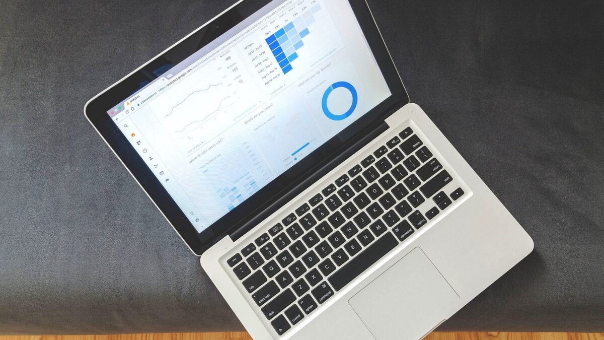 A laptop on a desk showing an analytics dashboard with charts