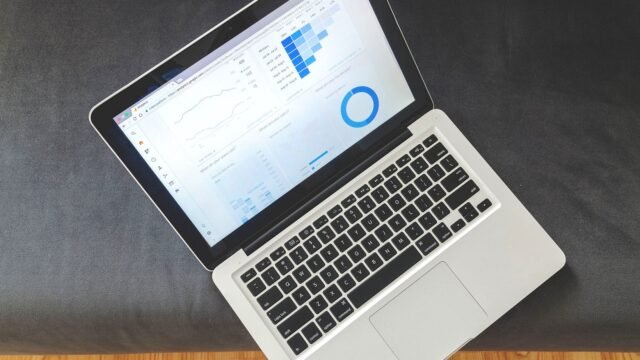 A laptop on a desk showing an analytics dashboard with charts