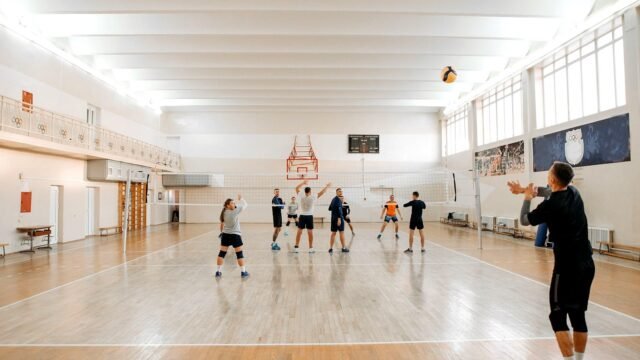 Players jumping at the net during an indoor volleyball match