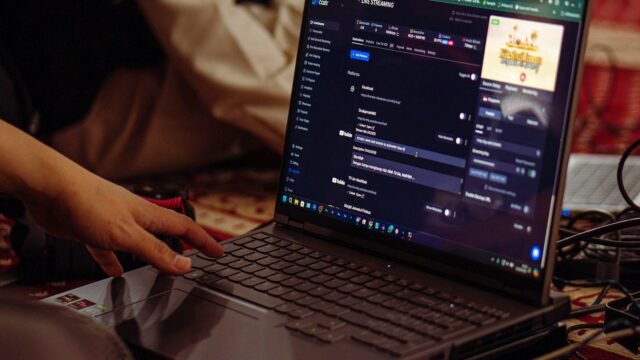 A person setting up a live stream on a laptop, emphasizing technology and connectivity.