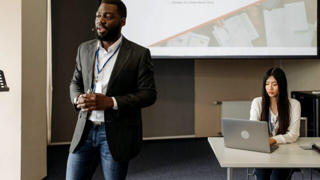 A team presenting slides to clients across a meeting room table