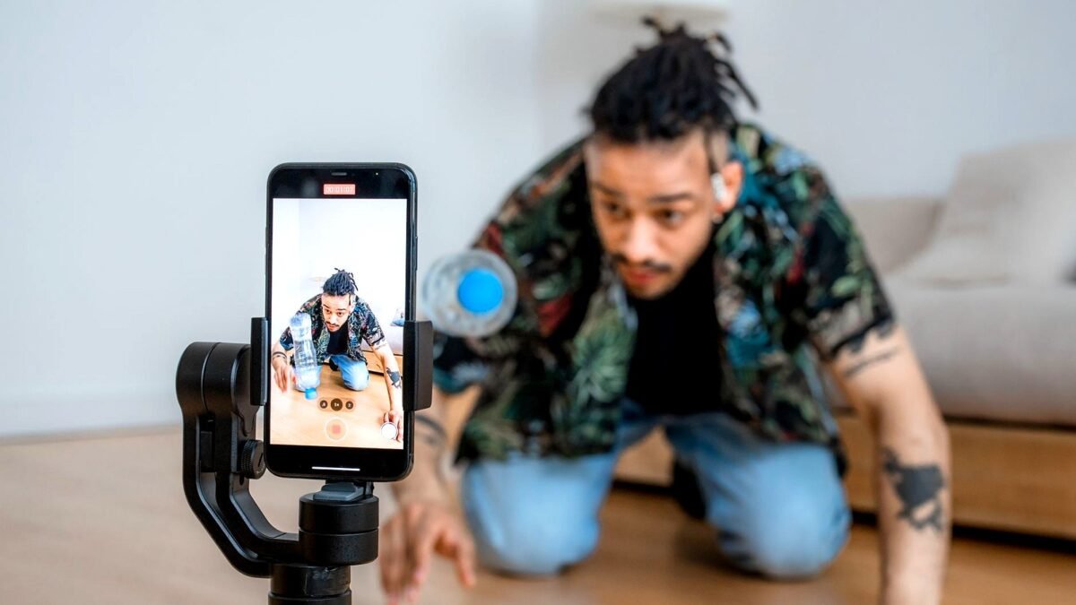 Content creator films a video on a smartphone mounted on a gimbal indoors
