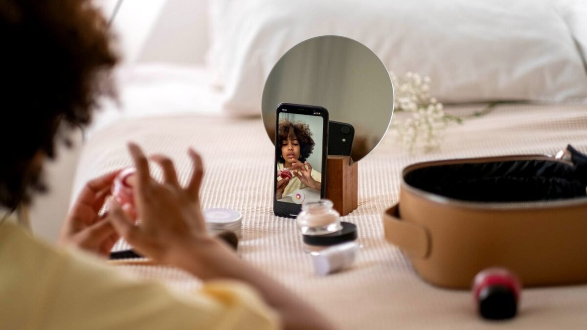 Creator films a product review at home with a phone on a tripod and cosmetics on the table