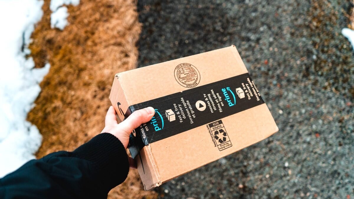 Hands holding a cardboard Amazon Prime parcel