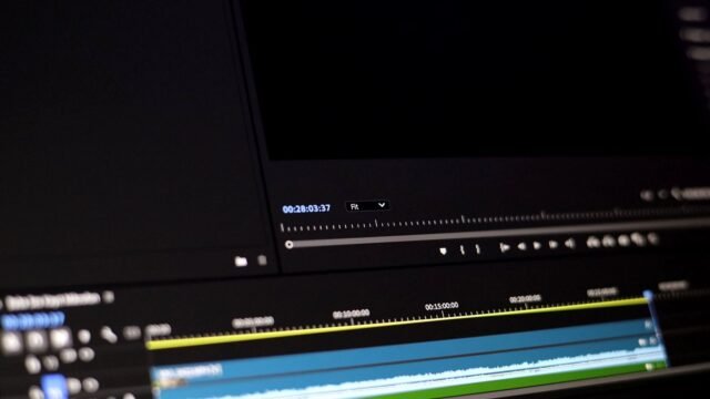 Video editing software on a monitor with a multi-track timeline and playback controls
