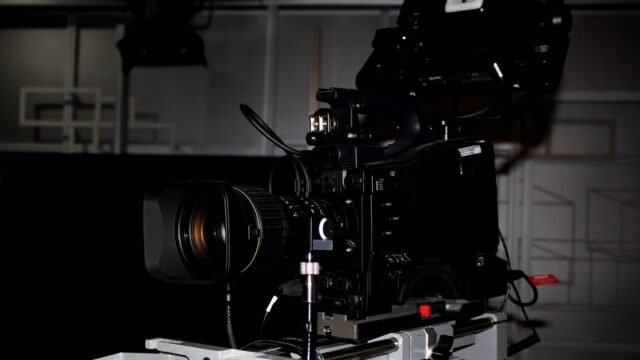 Close-up of a professional video camera rig in a television studio.