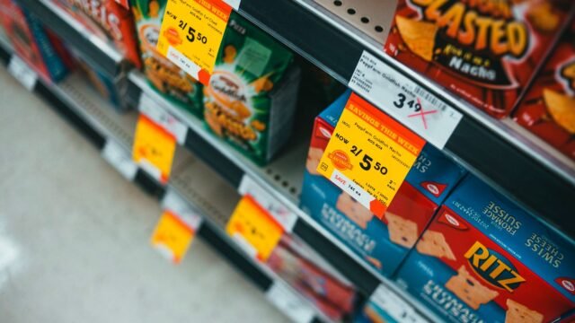 Supermarket shelf with snacks and yellow sale price tags