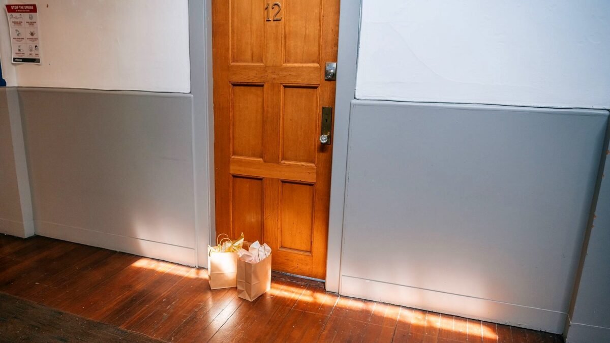 Paper grocery bags left outside a wooden apartment door